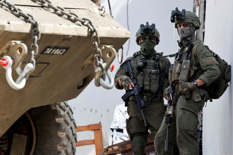 FILE PHOTO: Israeli soldiers stand next to a military vehicle during an Israeli raid in Jenin, in the Israeli-occupied West Bank, March 4, 2025. REUTERS/Raneen Sawafta/File Photo