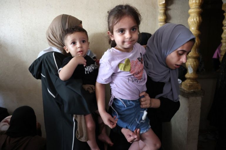 Relatives of media correspondent Anas al-Sharif, carry his 15-month-old son Salah (L) and 4-year-old daughter Sham (R) during his funeral in Gaza City on August 11, 2025. [Omar Al-Qattaa/AFP]