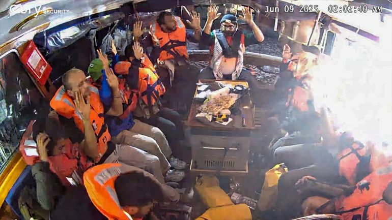 An image grab from footage released by the Freedom Flotilla Coalition on June 9, 2025 shows activists on board the Gaza-bound aid boat Madleen, with their hands in the air, as they are being intercepted by the Israeli forces in international waters before reaching the blockaded Palestinian territory.