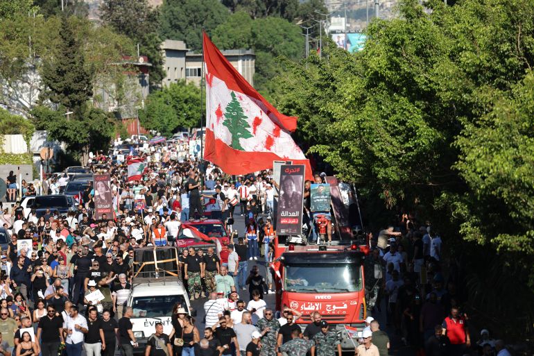 Protesters lift placards depicting the victims of the 2020 Beirut port blast