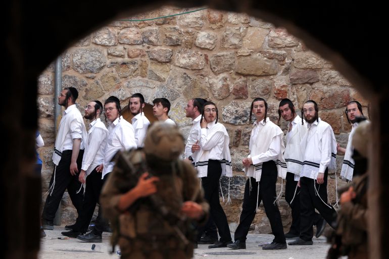 Israeli security forces stand guard as Israeli settlers tour in the old market in the Palestinian-side of Hebron in the occupied West Bank