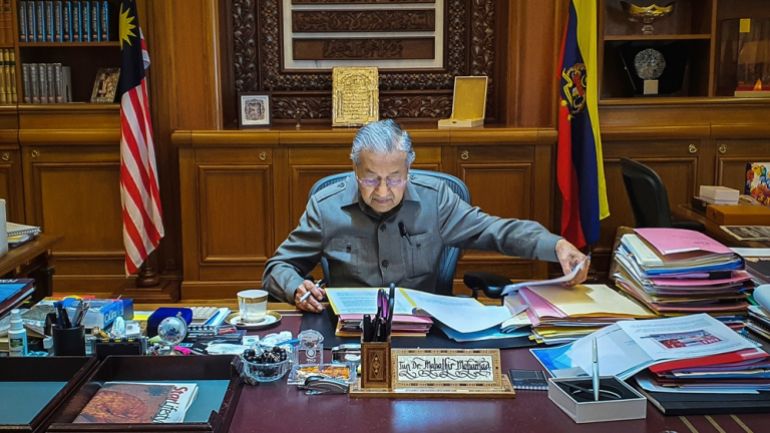 In this photo released by Prime Minister Office, Malaysian Prime Minister Mahathir Mohamad works at his office in Putrajaya, Malaysia, Tuesday, Feb. 25, 2020.