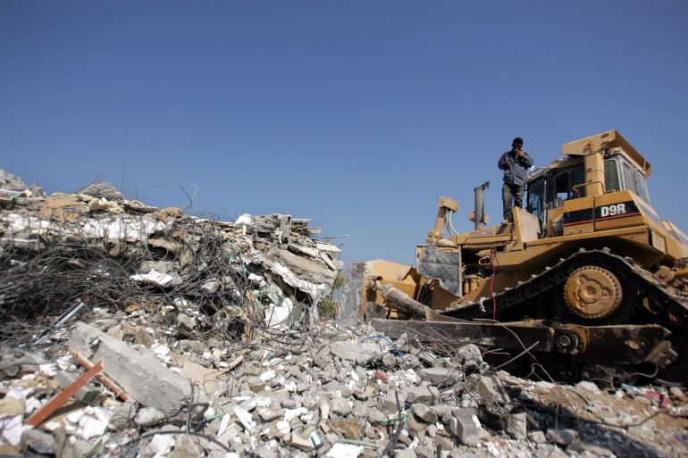 KFAR DAROM, GAZA STRIP - AUGUST 30: A bulldozer demolishes houses on August 30, 2005 in the Kfar Darom settlement in the Gaza Strip. After the Israeli pullout from Gaza which removed about 9,000 Jewish settlers from 21 settlements in Gaza and four in the northern West Bank, the Israeli Army is now demolishing all the settlements and is expected to leave the Gaza Strip in the coming weeks. (Photo by Marco Di Lauro/Getty Images)