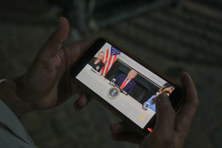 Palestinian paramedic Saeed Awad looks at his phone displaying an image of U.S. President Donald Trump