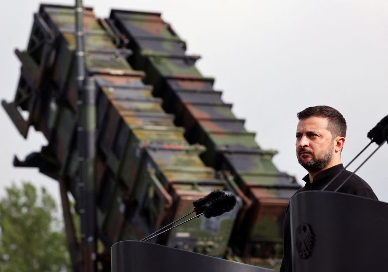 Ukrainian President Volodymyr Zelenskiy looks on during a visit to a military training area.