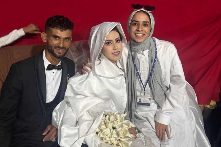 Maram Humaid poses with the newlyweds, Islam and Mohammad. [Courtesy of Maram Humaid]