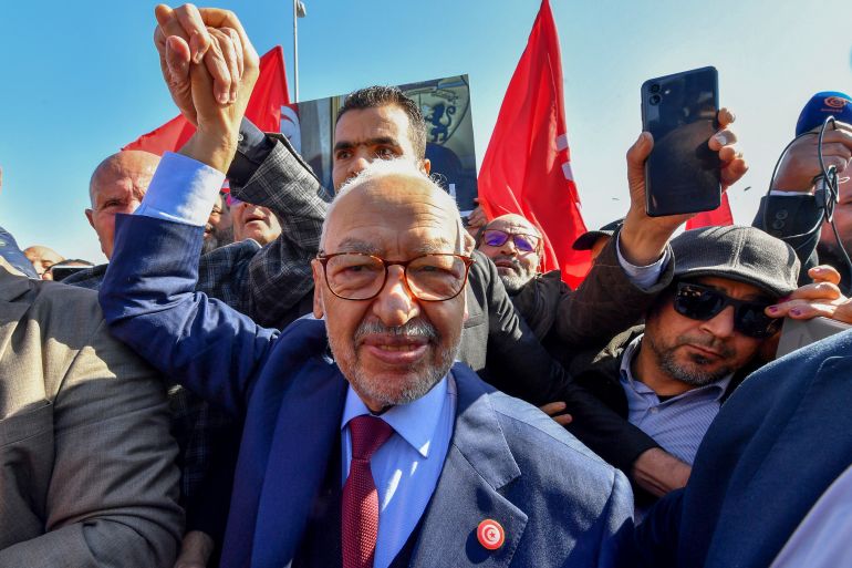 The head of Tunisia's Islamist movement Ennahdha Rached Ghannouchi greets supporters upon arrival to a police station in Tunis ,on February 21, 2023, in compliance to the summons of an investigating judge. (Photo by FETHI BELAID / AFP)