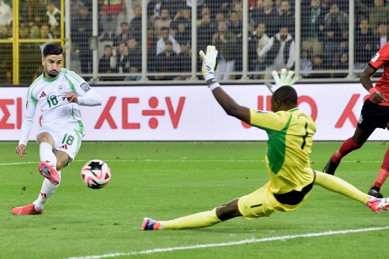 Algeria's Mohamed Amoura scores as Mozambique goalkeeper Ernan Siluane misses the ball during the World Cup 2026 group G qualifying soccer match between Algeria and Mozambique at the Hocine-Ait-Ahmed stadium in Boukhalfa, near Tizi Ouzou, eastern Algeria, Tuesday March 25, 2025. (AP Photo/Fateh Guidoum)