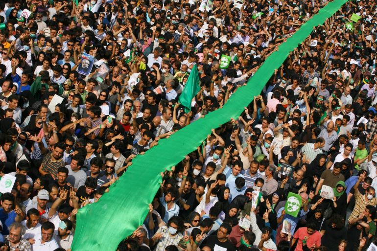 TEHRAN, IRAN - JUNE 15: Iranian supporters of defeated reformist presidential candidate Mir Hossein Mousavi carry a large green flag through the crowd as they demonstrate in the streets on June 15, 2009 in Tehran, Iran. Crowds of people gathered to protest the re-election of Iran's President Mahmoud Ahmadinejad, who won a second four-year term in a landslide election victory on June 12. (Photo by Getty Images)