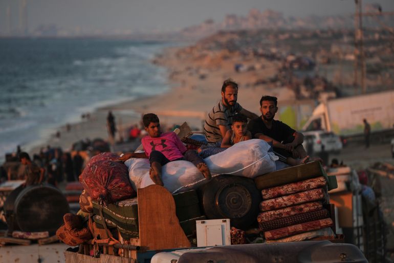 Displaced Palestinians flee Gaza City carrying their belongings along the coastal road toward southern Gaza,