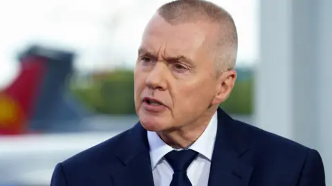 Getty Images Willie Walsh wears a suit and tie.