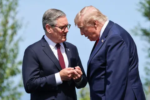 AFP via Getty Images Britain's Prime Minister Keir Starmer and US President Donald Trump speak during a family photograph during the G7 summit, in Evian, eastern France, on June 16, 2026. 