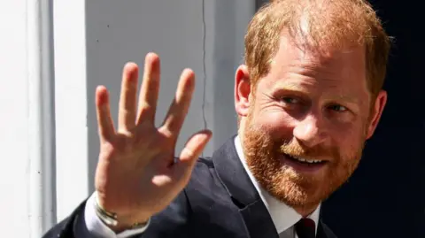 Reuters Close up photo of Prince Harry smiling and waving