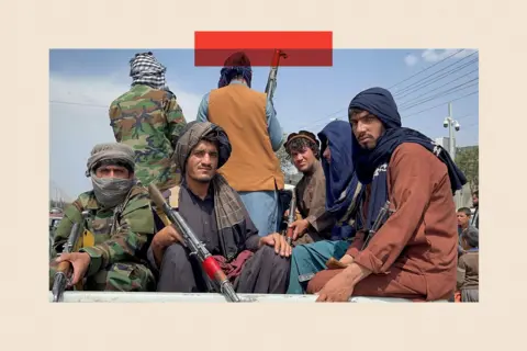 Reuters Taliban fighters in traditional clothes and holding weapons sit on the back of an open-top vehicle 