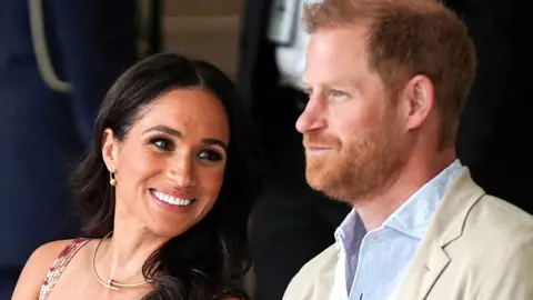 Reuters Prince Harry and Meghan sat next to each other and smiling in Colombia in 2024