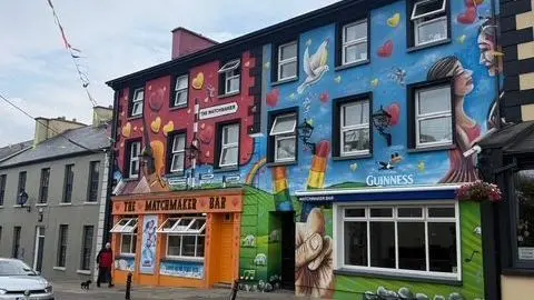 Mary Timby Lisdoonvarna's colourful Matchmaker Bar stands out from the typical Irish street, its exterior painted in orange, blue and other shades for a mural showing sheep, the Guinness mascot, a rainbow and other images. A man walks his dog in front of the pub while a car passes