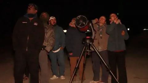 BBC Marathi Tsering Yangdol points laser at the sky to help tourists spot stars visible to the naked eye
