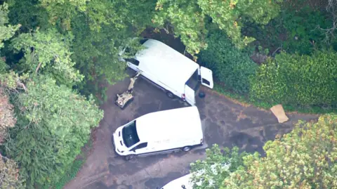 Aerial footage of robot and white vans near RAF Fairford.