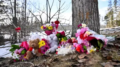 Reuters Flowers and toys lie on the ground near the site of a mass shooting at a high school, in the town of Tumbler Ridge, British Columbia, Canada February 11.