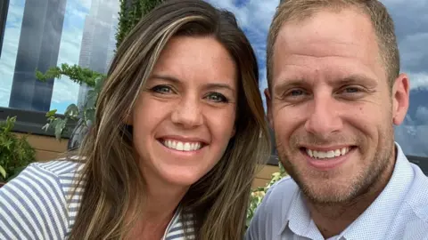 Facebook/Ashley Flynn Ashley Flynn, seen in a 2023 Facebook photo, alongside her husband. They both are smiling