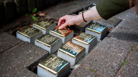 Getty Images Small blocks of stone with brass on top are placed as part of a memorial on the pavement in front of houses where Jewish victims lived in Nijmegen in the Netherlands