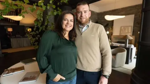 Mary Timby Timby's brown hair tumbles over her shoulders as she poses in a green blouse and jeans next to bearded boyfriend Jason Mangan, 38, wearing a beige cardigan, table books and manicured furniture visible in the background