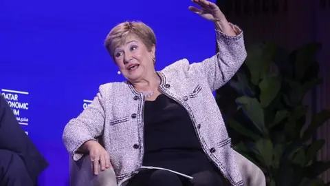 Getty Images Kristalina Georgieva, managing director of the IMF, speaking during the Qatar Economic Forum in New York, US, this month. She sitting down in a chair explaining her answer to a question as she raises her left arm above her head.