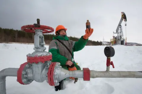 Bloomberg via Getty Images A worker checks a sample of oil near an oil pumping jack, also known as a "nodding donkey," operated by Tatneft PJSC, pump oil on an oilfield near Almetyevsk, Tatarstan, Russia, on Tuesday, March 6, 2019. Tatneft explores for, produces, refines, and markets crude oil. Photographer: Andrey Rudakov/Bloomberg via Getty Images