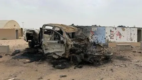 CBS News An undated photo, obtained by CBS News from active duty service members, shows car reportedly destroyed in an Iranian strike at Camp Buehring, Kuwait.