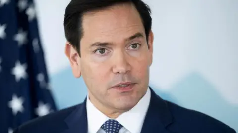 Reuters A close-up of Marco Rubio wearing a dark suit with white shirt and dotted tie 