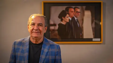 Silas Malafaia standing in front of a picture of Bolsonaro Senior