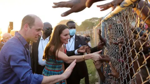 Chris Jackson-Pool/Getty Images Prince William, Duke of Cambridge and Catherine, Duchess of Cambridge shake hands with children through a wire fence during a visit to Trench Town