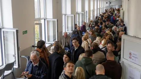 Reuters People wait in line to cast their votes during the parliamentary election in Belgrade, Serbia