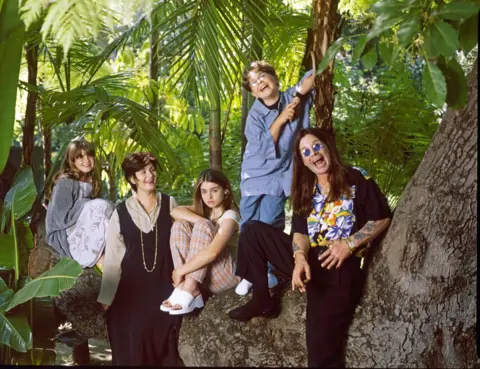 Getty Images Osbourne family portrait when the children were young with members standing against and sitting on a tree in a forest
