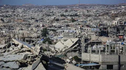 AFP via Getty Images Grey, ruined buildings stretch into the distance. 