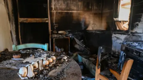 Getty Images A burnt kitchen, blackened with smoke and charred furniture. 