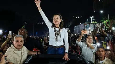 Getty Images Opposition leader Maria Corina Machado greets the crowd gathered around her vehicle on October 25, 2026 in Caracas, Venezuela