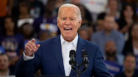Getty Images US President Joe Biden at a campaign event at Renaissance High School on July 12, 2024 in Detroit, Michigan. He wears a blue suit jacket and a white shirt