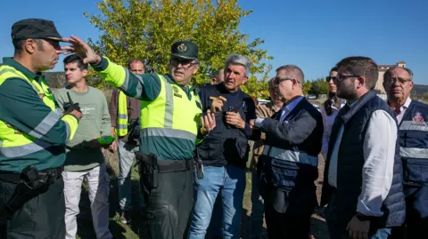 Europa Press via AP The President of Castilla-La Mancha, Emiliano García-Page (2nd from left), and the Government Delegate for Castilla-La Mancha, José Pablo Sabrido (3rd from left), are briefed on the accident by those working at the scene, on 28 October 2026, in Urda, Toledo, Castilla-La Manch