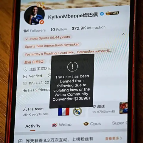 AFP via Getty Images This photo illustration shows French football star Kylian Mbappe's Chinese social media Weibo account displaying the message: "The user has been banned from following due to violating laws of the Weibo Community Convention".