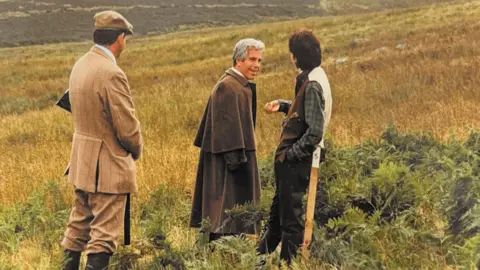 US Department of Justice An undated picture of Jeffrey Epstein and Ghislaine Maxwell dressed in country clothing with someone who appears to be a gamekeeper, near Balmoral