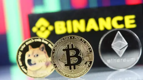 Getty Images Binance logo is seen together with representations of cryptocurrencies. File photo