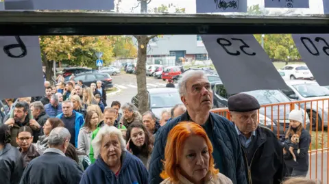 Reuters People queue outside a polling station to vote during the parliamentary election in Novi Sad, Serbia,