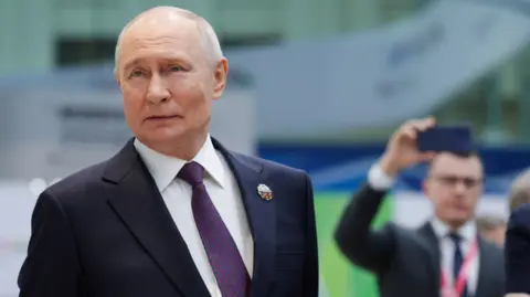 Reuters Russian President Vladimir Putin looking to the side as he stands during a presentation of Russian technology at the Russia-Africa Summit.