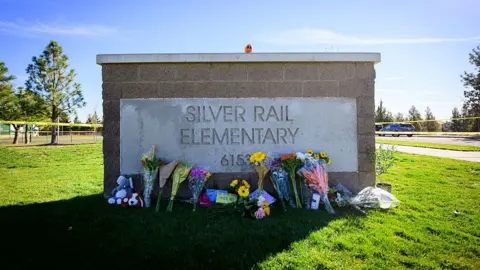Getty Images Flowers lay against the entry sign of Silver Rail Elementary School on October 16, 2026 in Bend, Oregon.