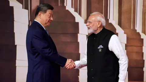 AFP via Getty Images India's Prime Minister Narendra Modi (R) shakes hands with China's President Xi Jinping before the start of the 18th BRICS Summit in Delhi on 18 September 2026. 