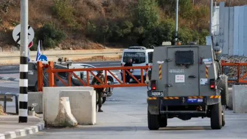 Reuters An Israeli army vehicle passes near the closed entrance of Hebron, in the Israeli-occupied West Bank
