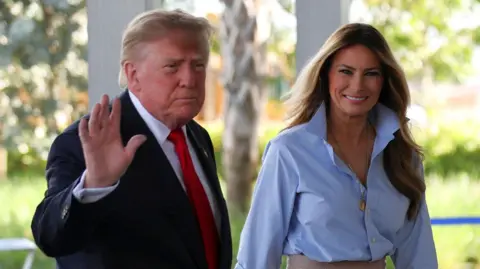 Reuters Donald Trump waves as he walks next to a smiling Melania Trump
