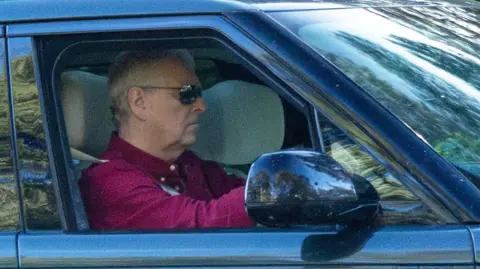 Bav Media Andrew Mountbatten-Windsor driving a Range Rover in Sandringham on Friday. He is spotted wearing sunglasses and a maroon shirt.