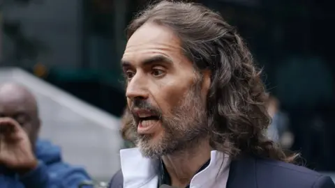Getty Images Russell Brand arrives at court ahead of his trial, where he faces rape and sexual assault charges at Southwark Crown Court on October 28, 2026 in London, England